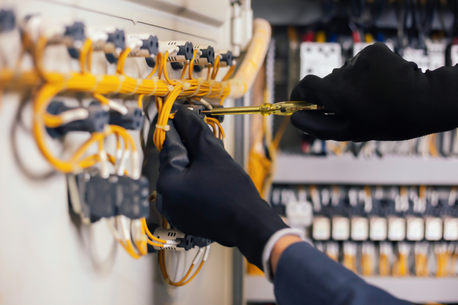 ingeniero eléctrico que mide la tensión y la corriente de la línea eléctrica en el control del gabinete eléctrico.y cables en el sistema de protección de relés